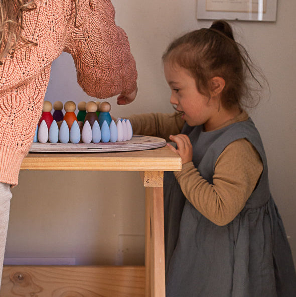 Child playing with wooden toys at a small table