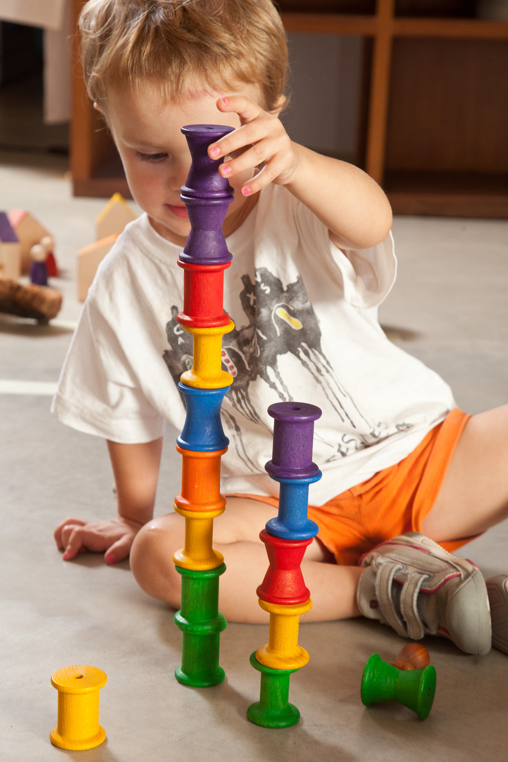 Child playing with colorful building blocks on the floor