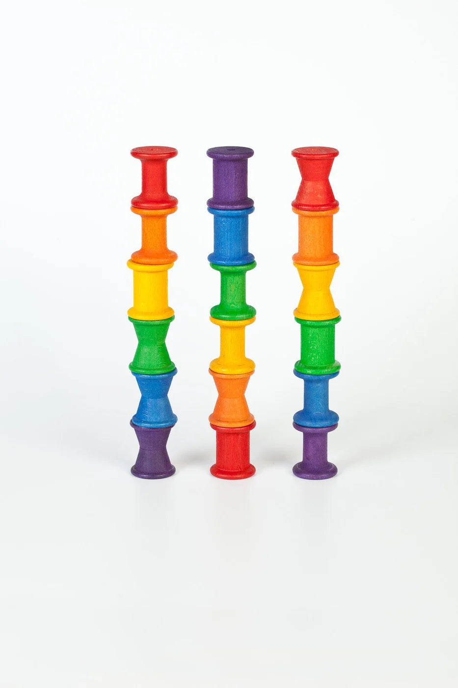 Set of colorful cylindrical toys stacked on a white background