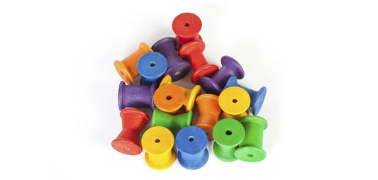 Colourful wooden spools on a white background