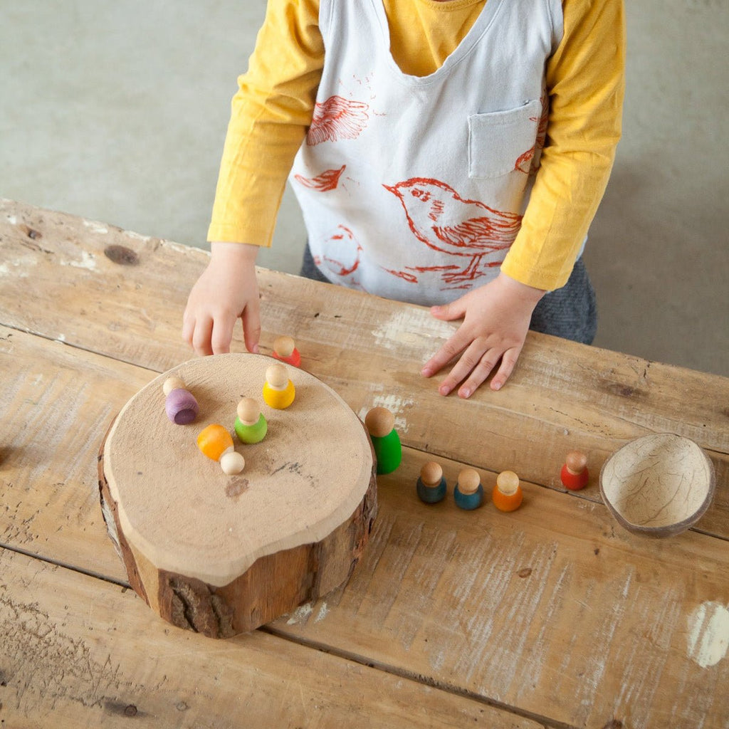 Child playing with colorful toys on a wooden surface