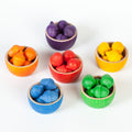 Set of colorful wooden bowls with toy fruits and vegetables on a white background