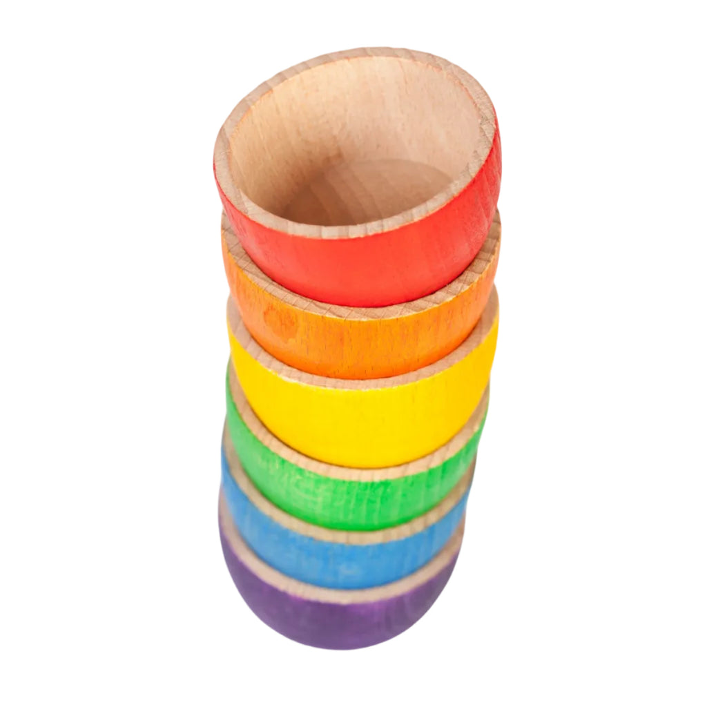 Stack of rainbow-colored wooden cups on a white background