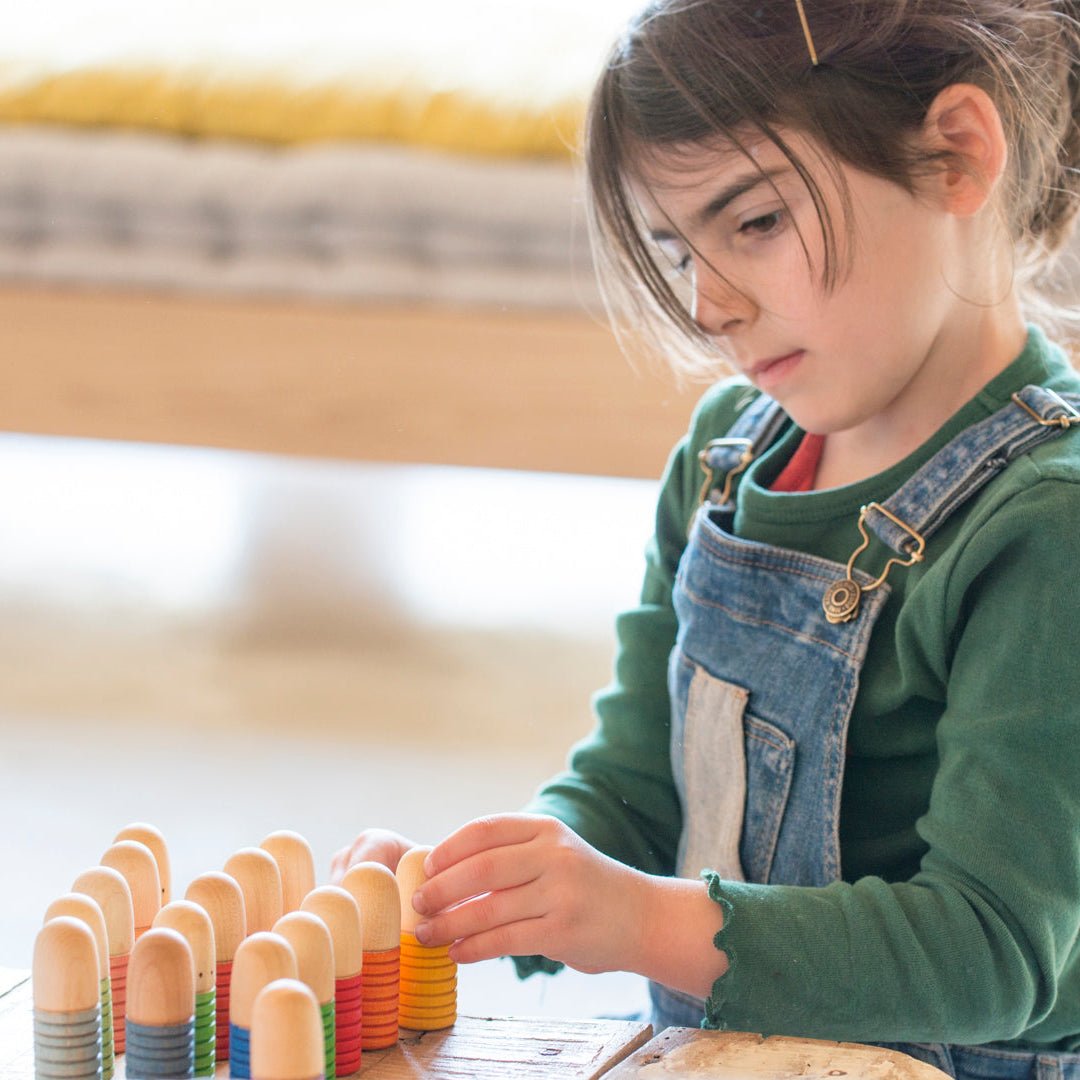 Child playing with colorful wooden toys in a home setting