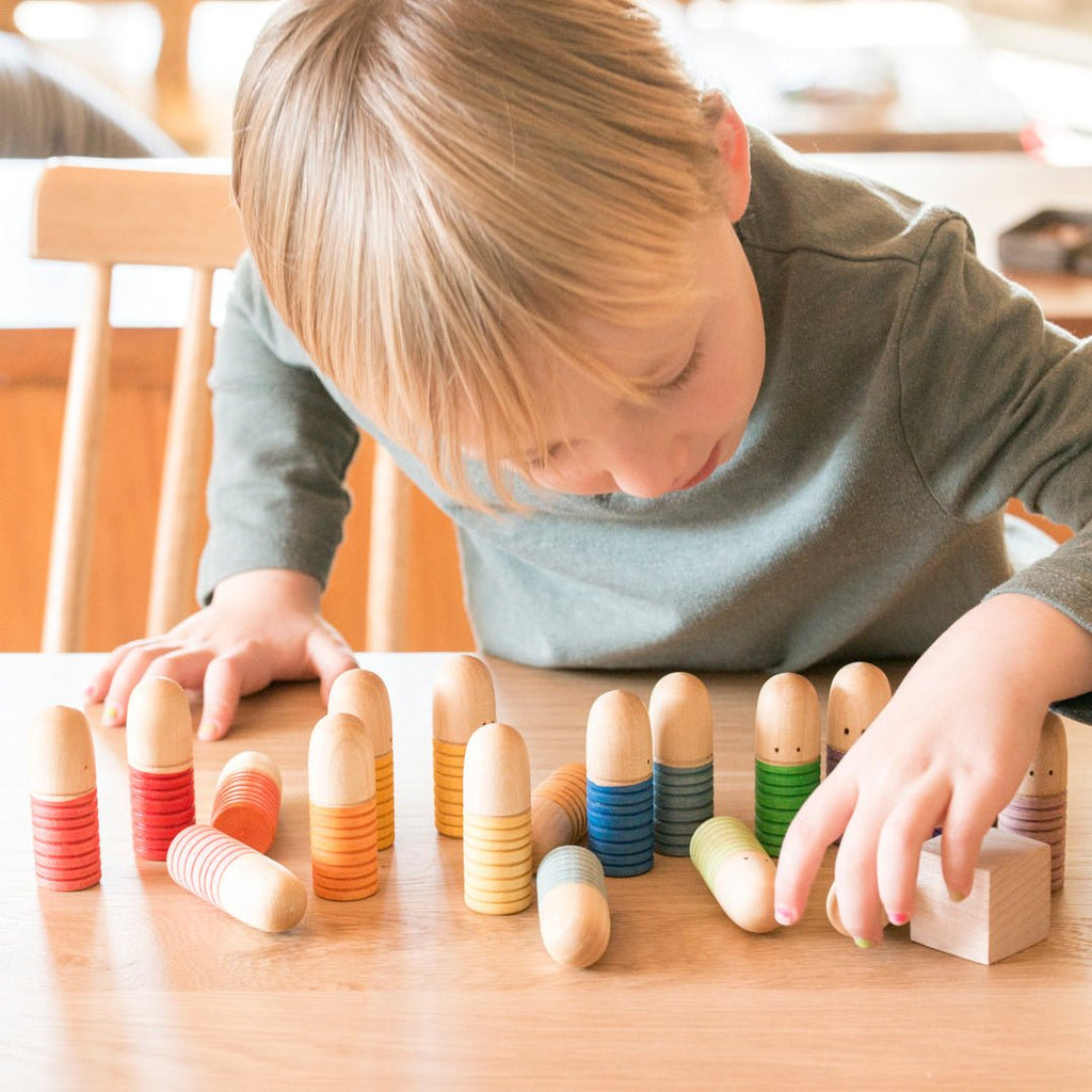 Child playing with colorful wooden blocks on a table