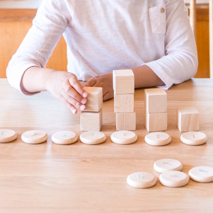 Young girl playing with wooden blocks on a table