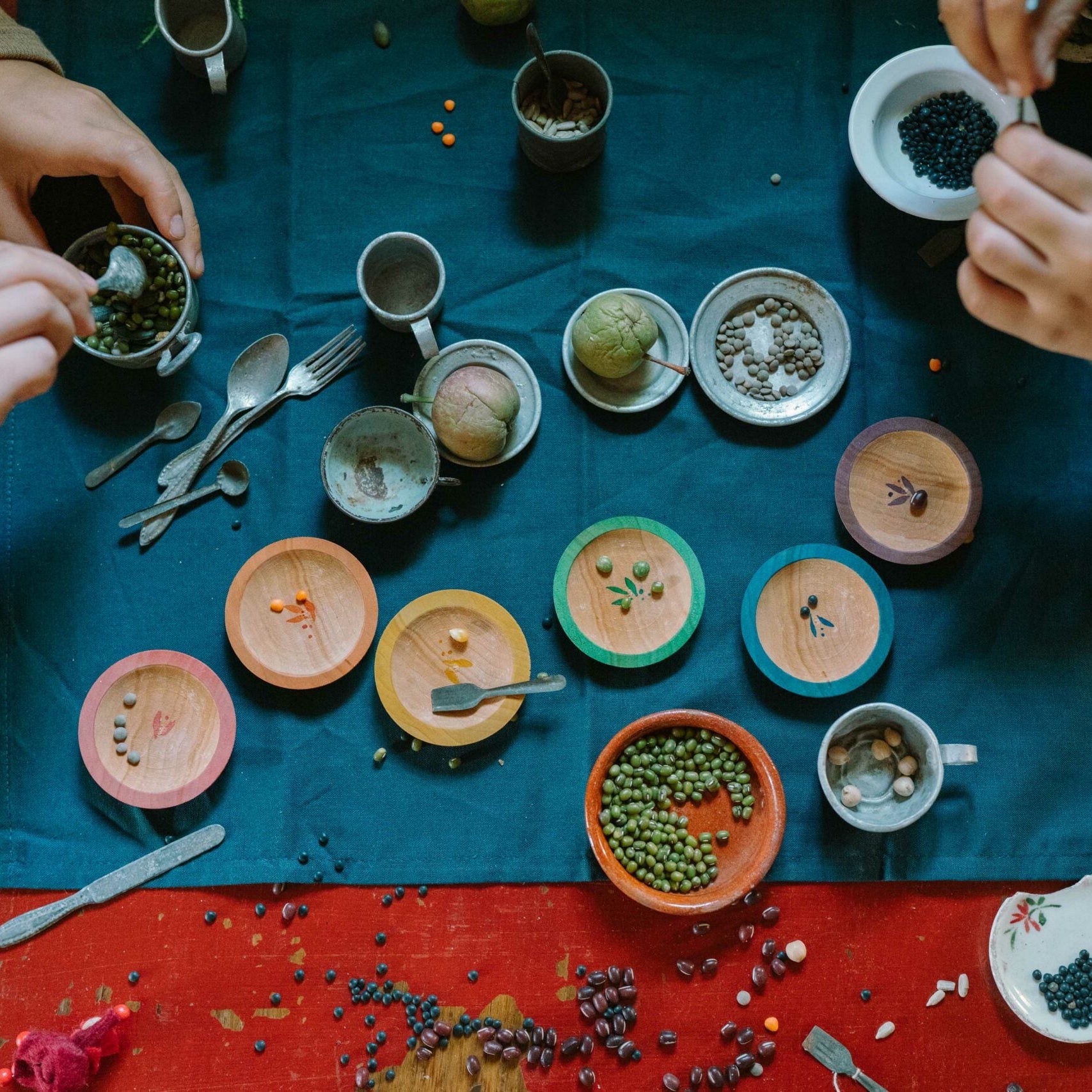 Two people preparing food on a table with various ingredients and utensils.