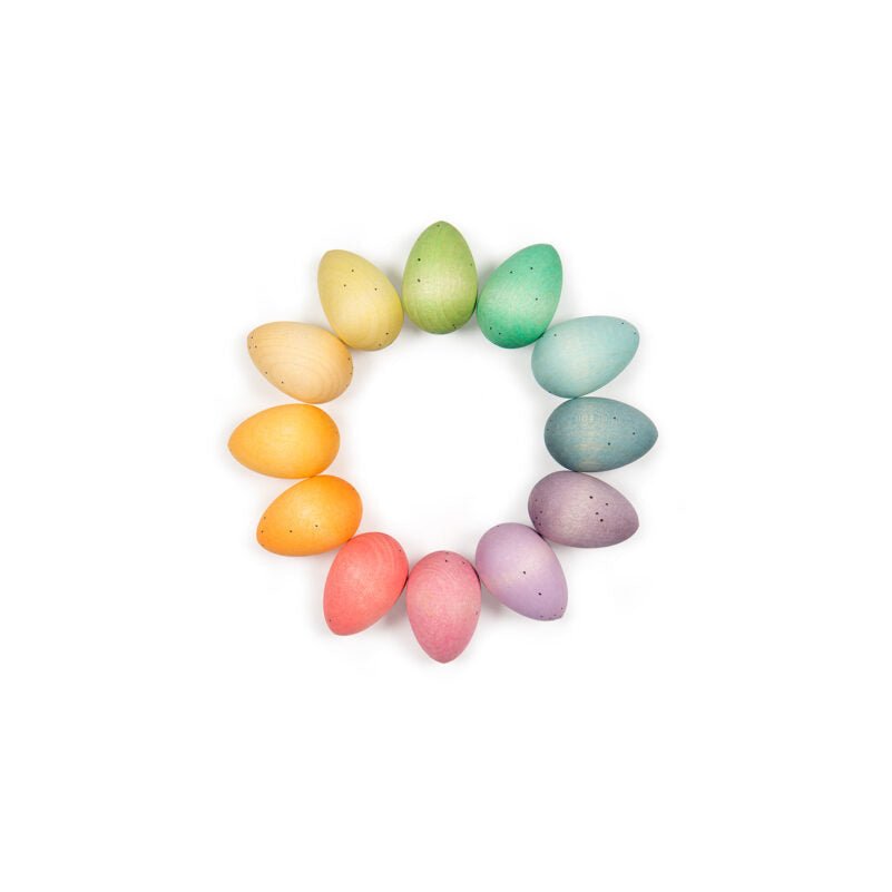 Pastel-colored candy eggs arranged in a circular pattern on a white background