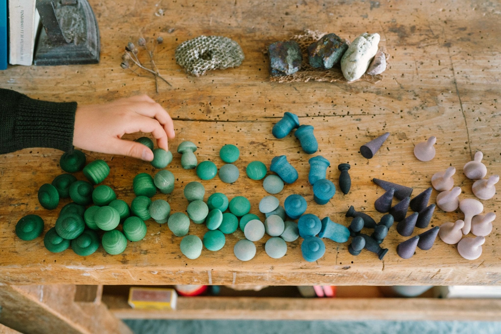 Colorful mandala on a wooden table with a hand reaching out.