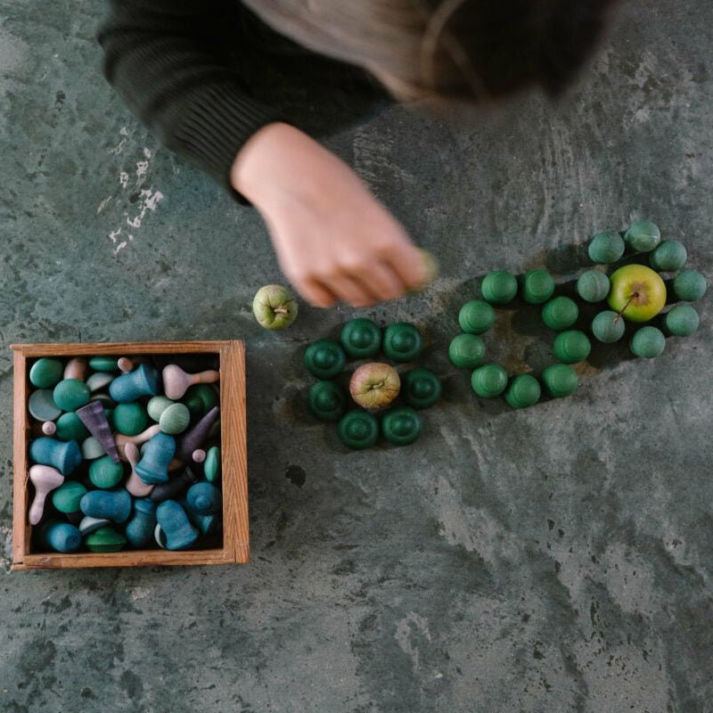 Person arranging colorful mandala on a textured surface