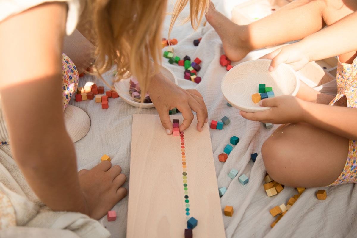 Two children playing with colorful blocks on a blanket