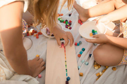 Two children playing with colorful blocks on a blanket