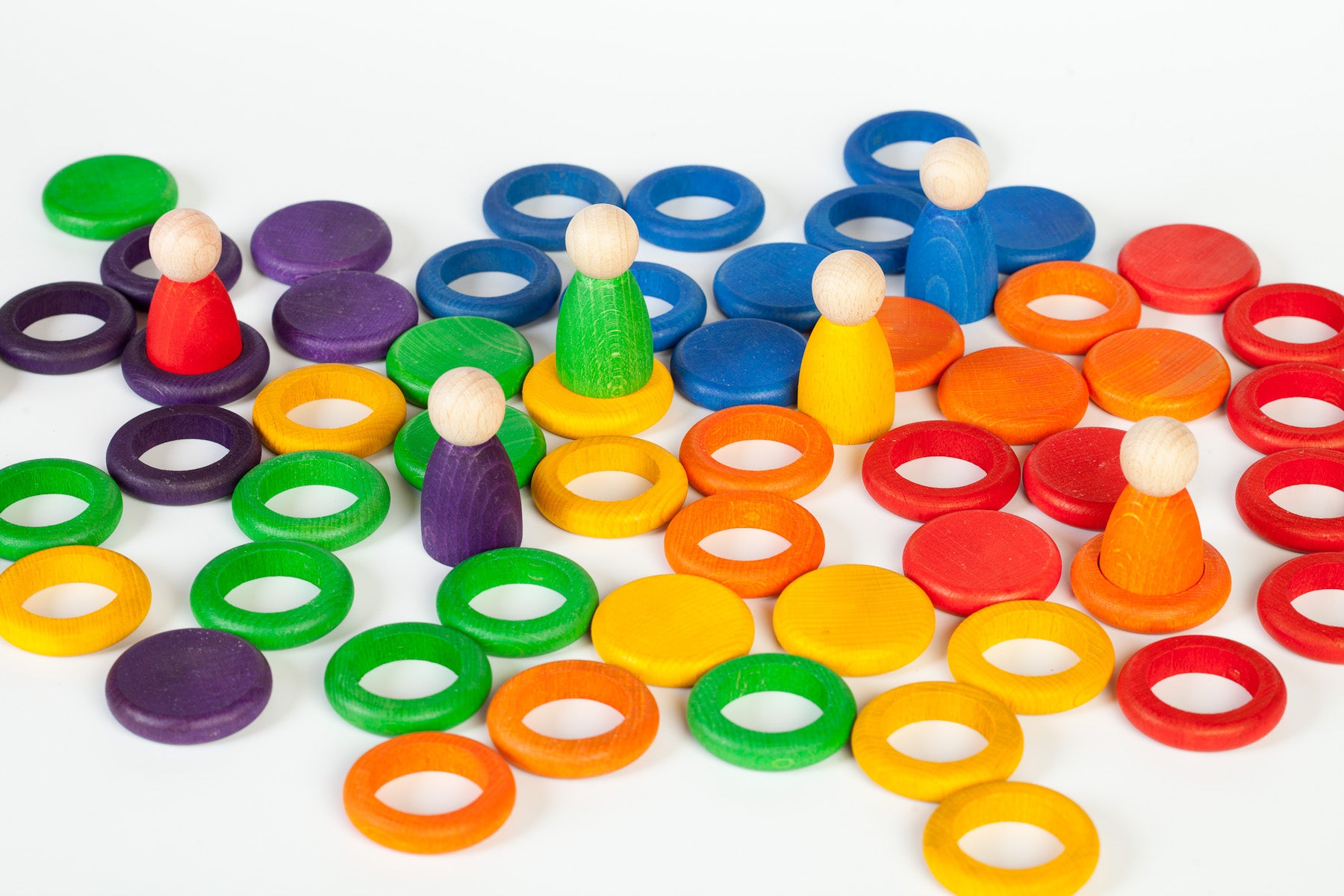 Colorful wooden rings and figures on a white background