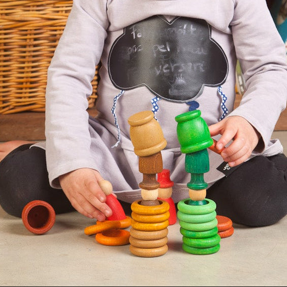 Child playing with colorful toys in front of a bookshelf