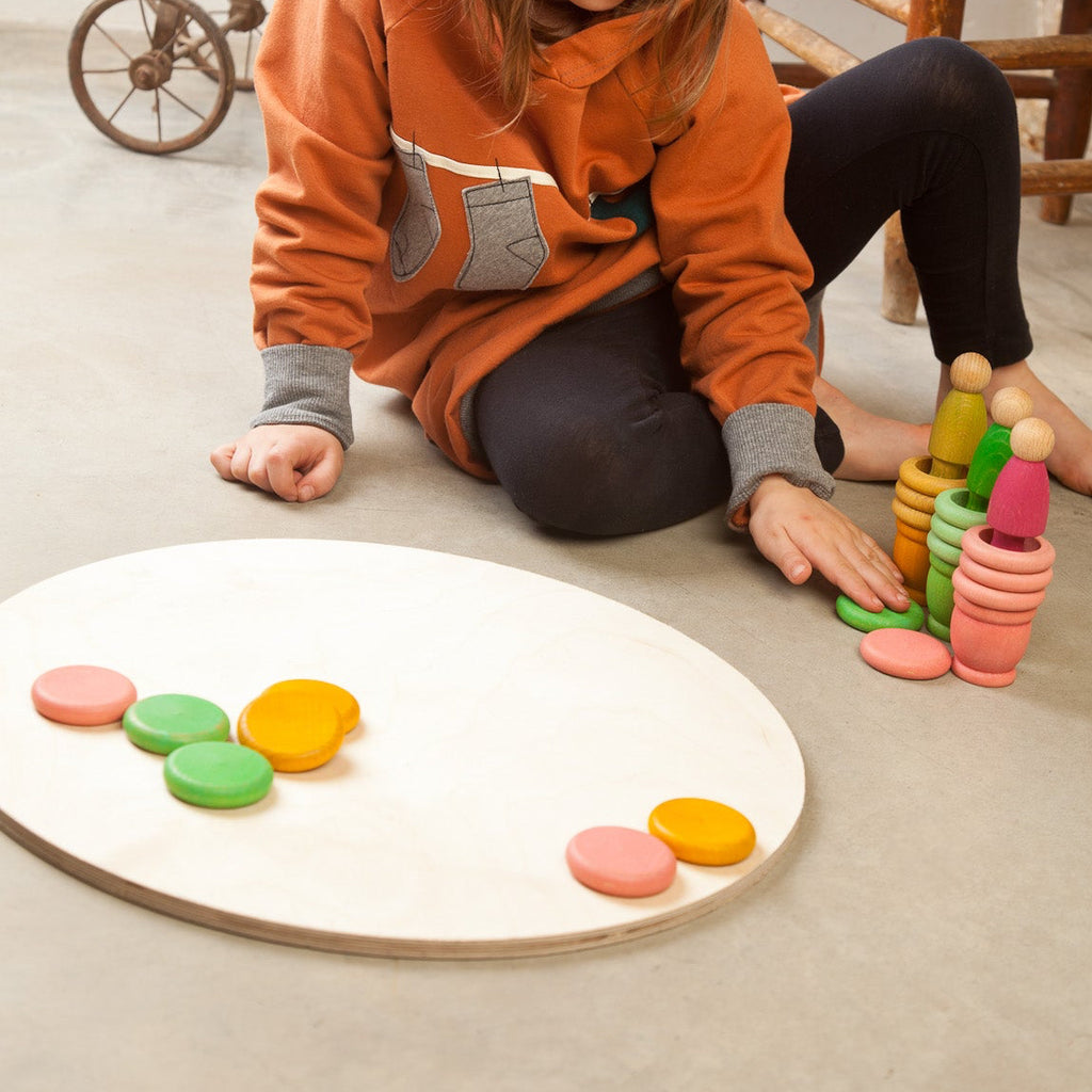 Child playing with colorful toys on a wooden floor