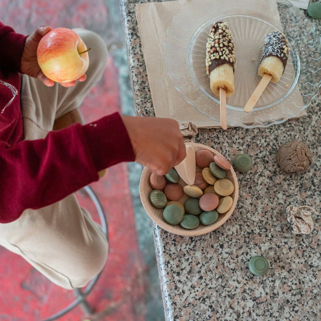 Child playing with stones on a countertop next to ice cream cones
