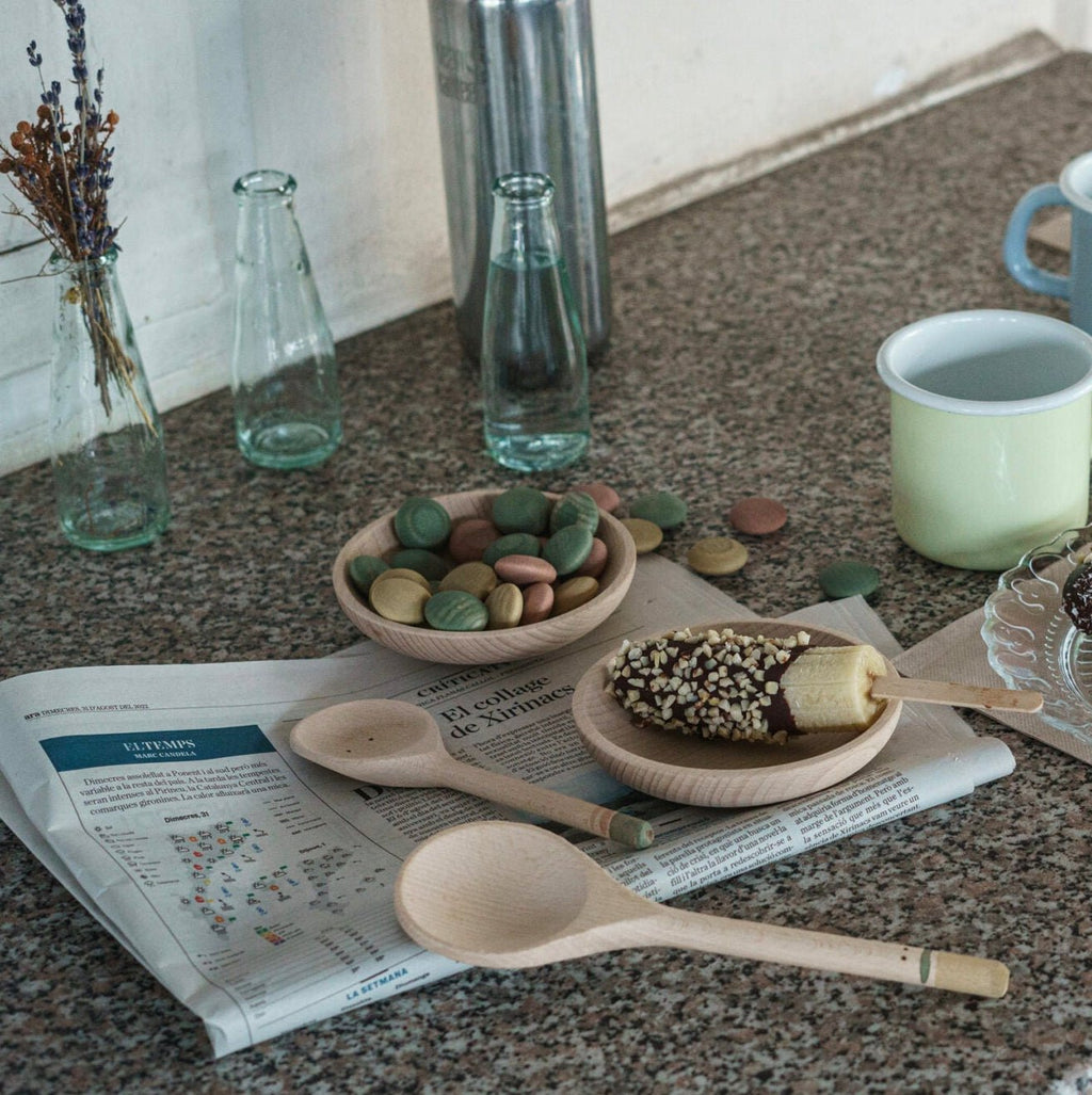 Table with snacks, cups, and a newspaper in a casual setting