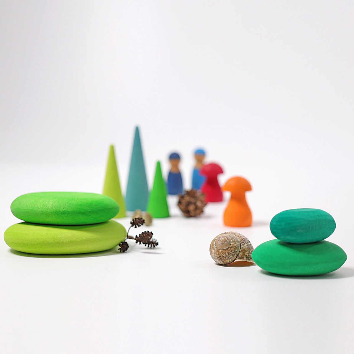 Colorful wooden toys including trees, animals, and people on a white background