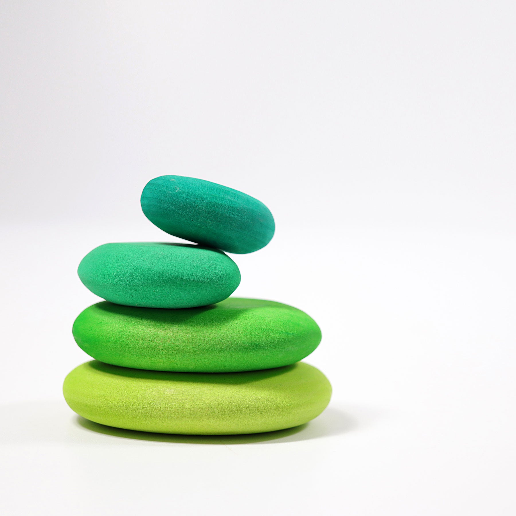 Stack of green wooden rings on a white background