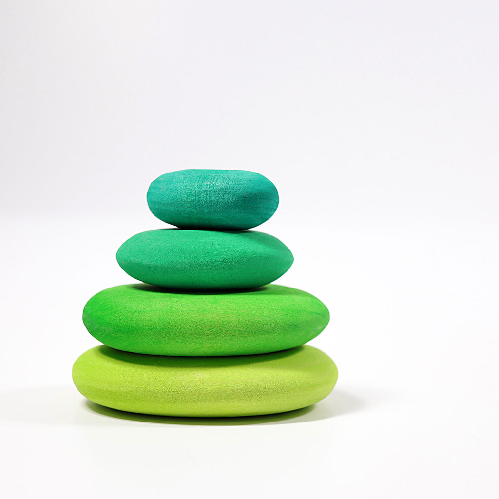 Stack of green wooden toys on a white background