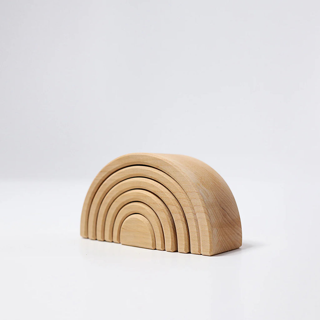 Wooden rainbow-shaped toy on a white background