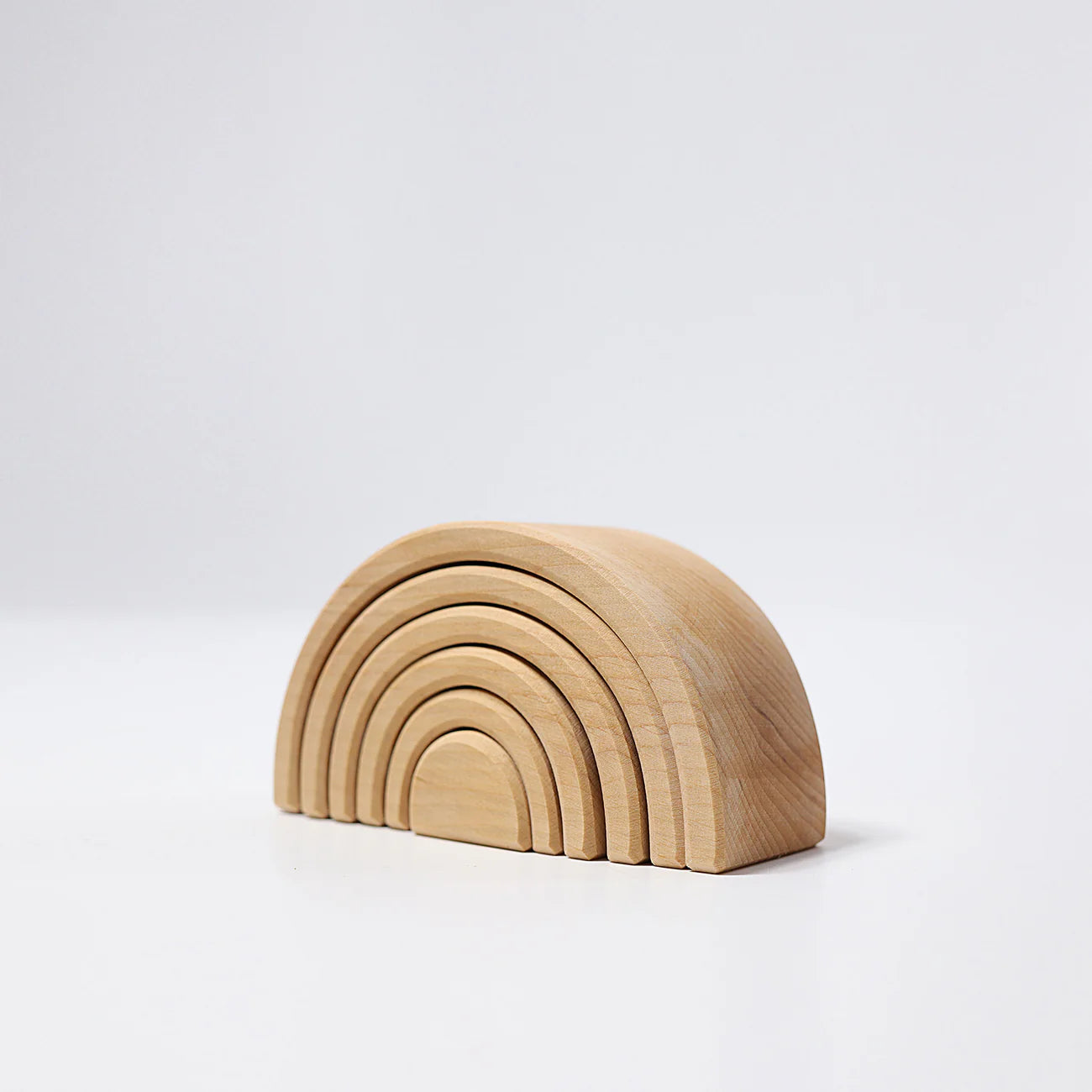 Wooden rainbow-shaped toy on a white background