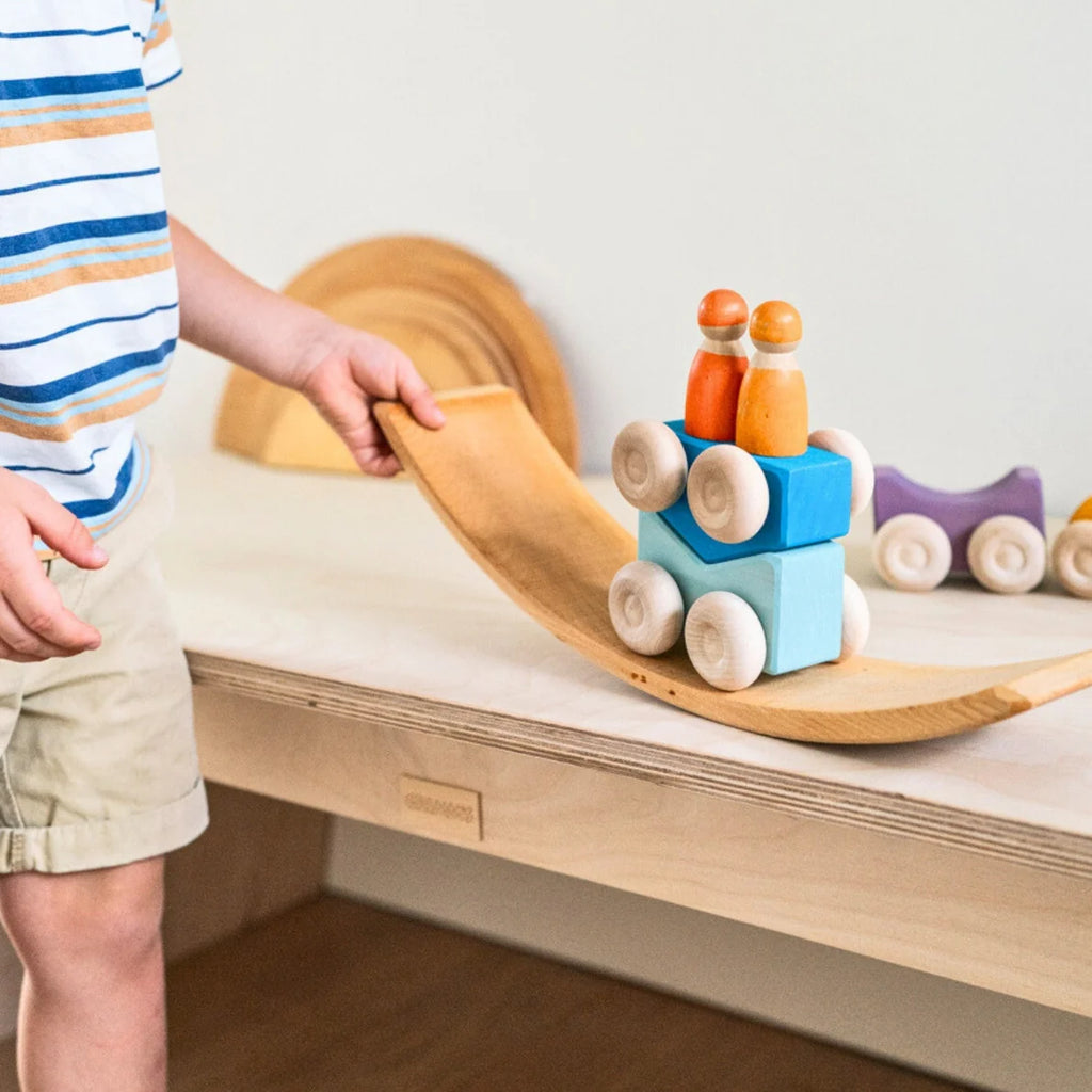 Child playing with wooden toys on a wooden shelf