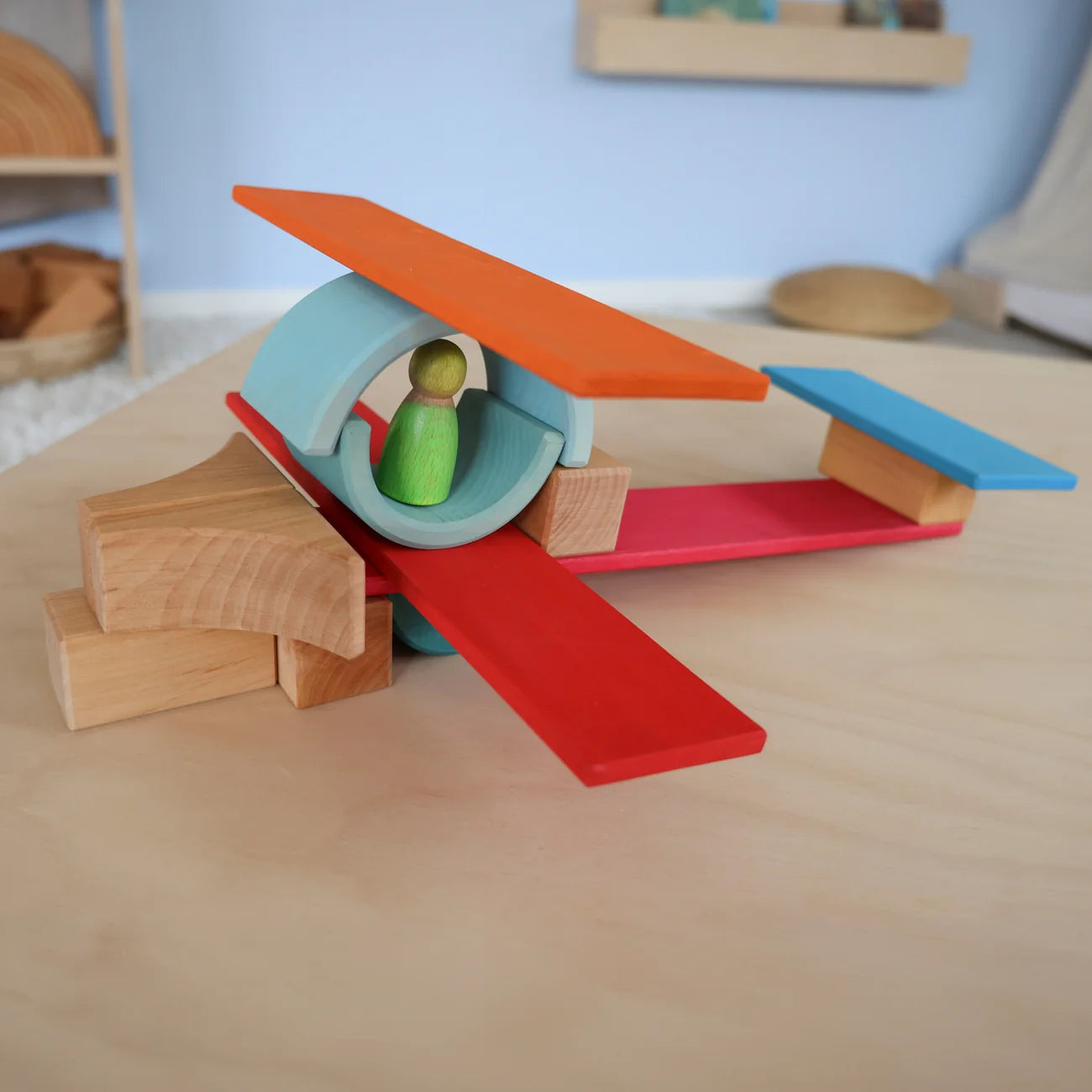 Colorful wooden toy airplane on a wooden surface with a blurred background