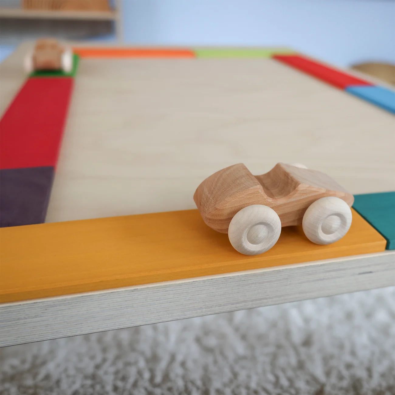 Wooden toy car on a colorful wooden track