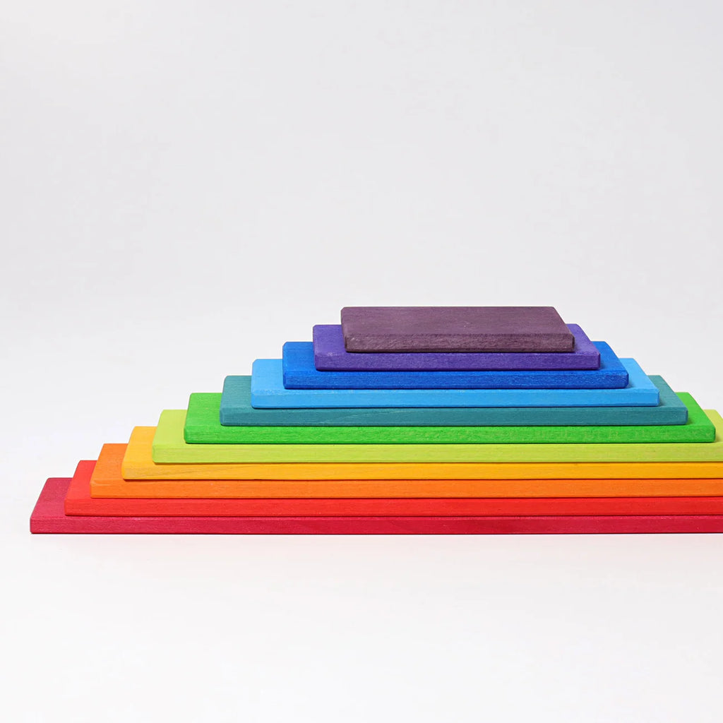 Stack of rainbow-colored wooden blocks on a white background