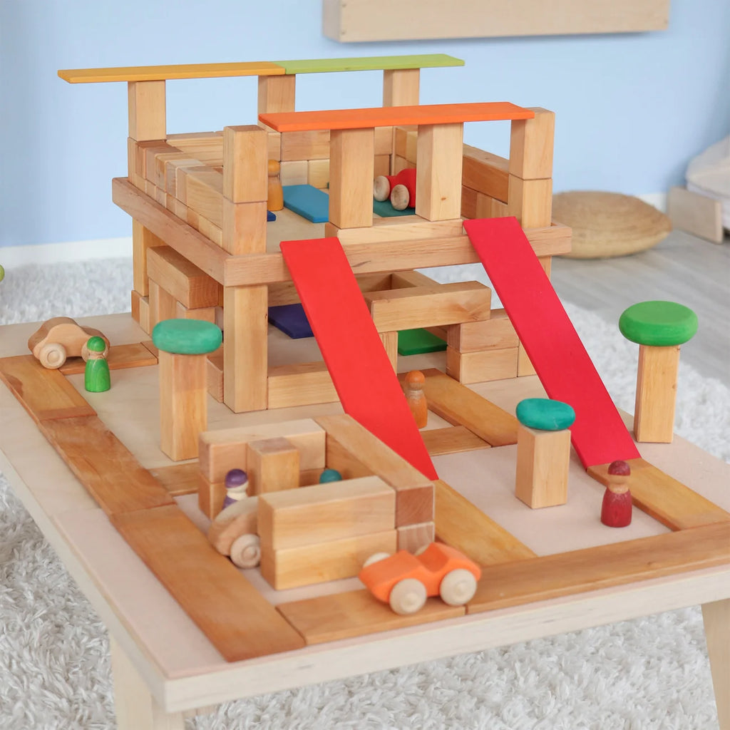 Wooden toy track set with cars on a light blue background