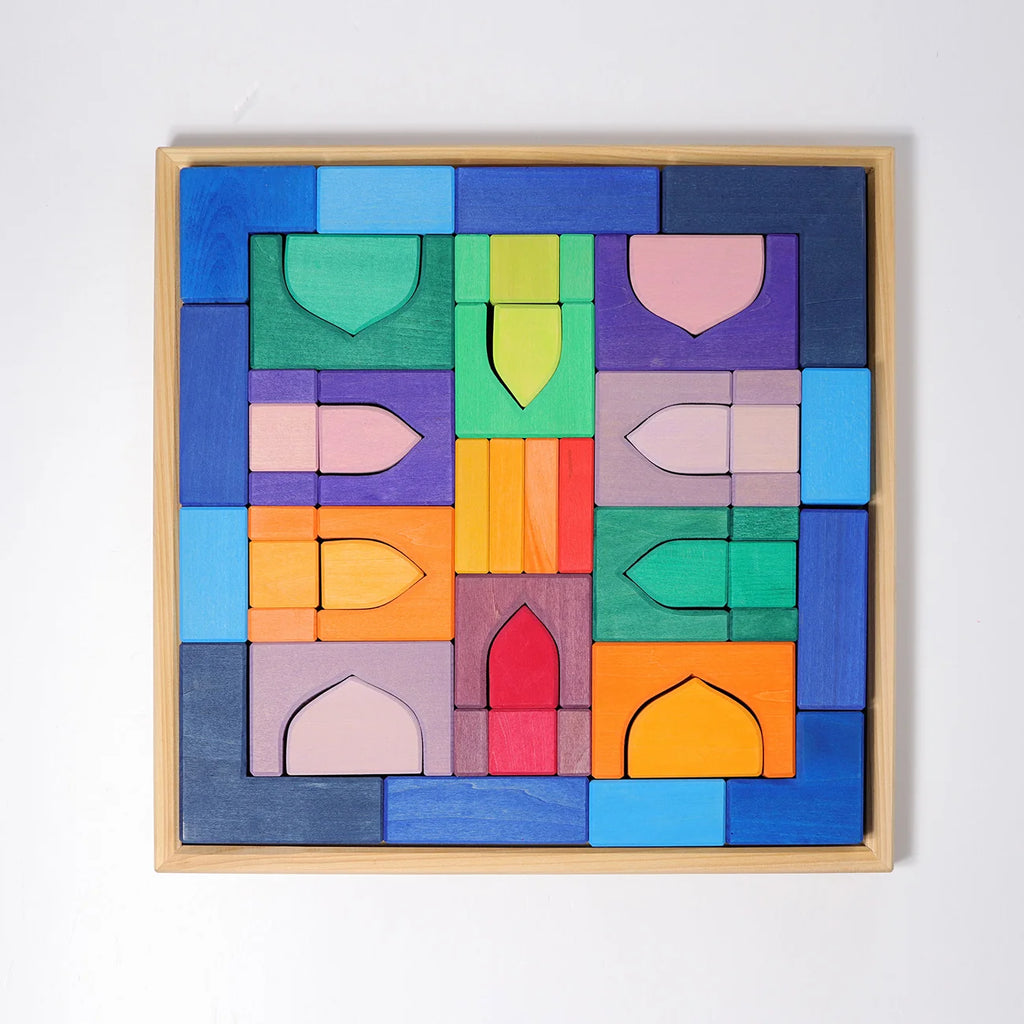 Colorful wooden puzzle blocks in a wooden frame on a white background