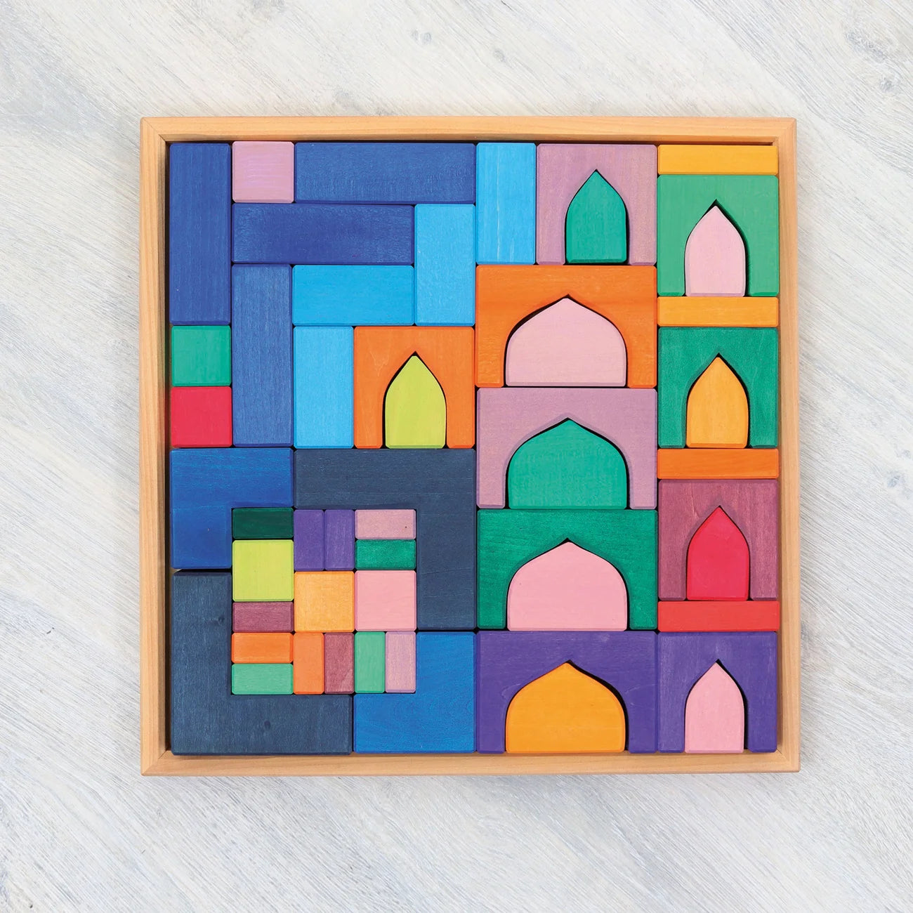 Colorful wooden block puzzle in a wooden frame on a light gray background