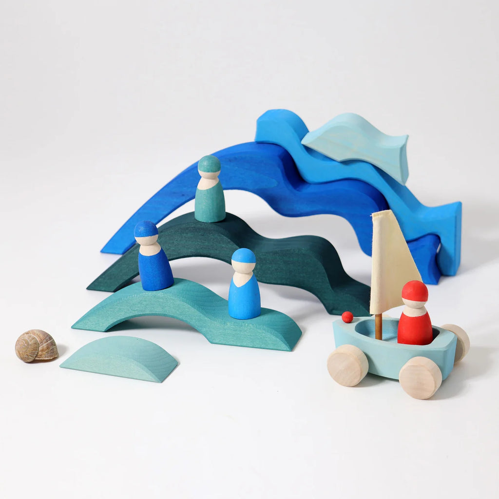 Wooden toy set with a sailboat and wave-shaped bridge on a white background