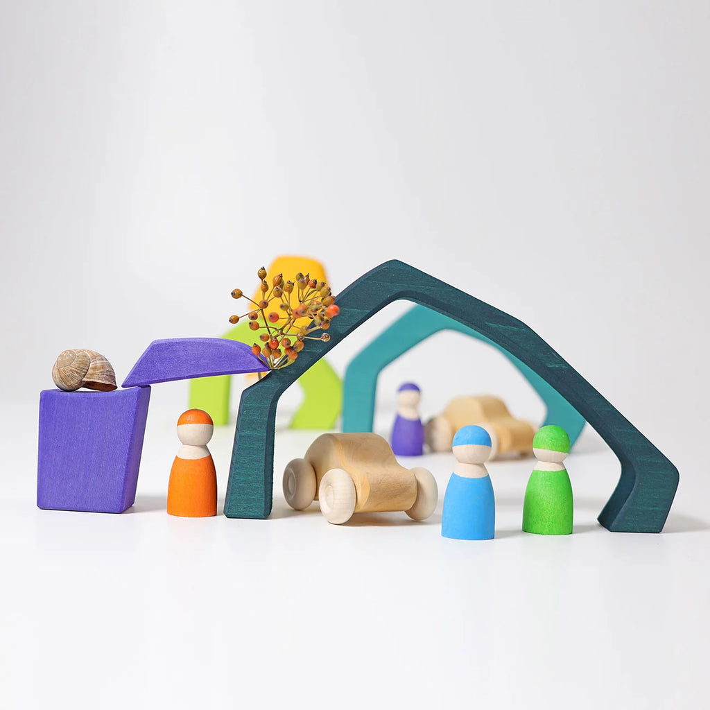 Colorful wooden toy figures and structures on a white background