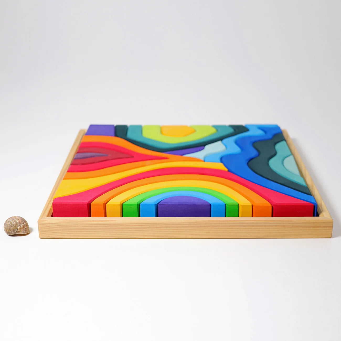 Colorful wooden blocks in a wooden tray on a white background