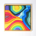 Colorful abstract art piece in a wooden frame on a white background