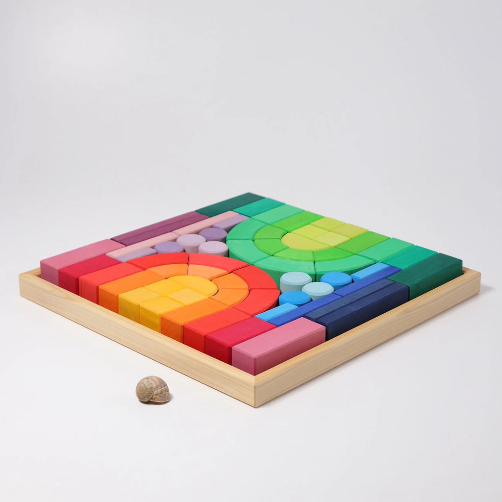 Colorful wooden blocks arranged in a geometric pattern on a light gray background