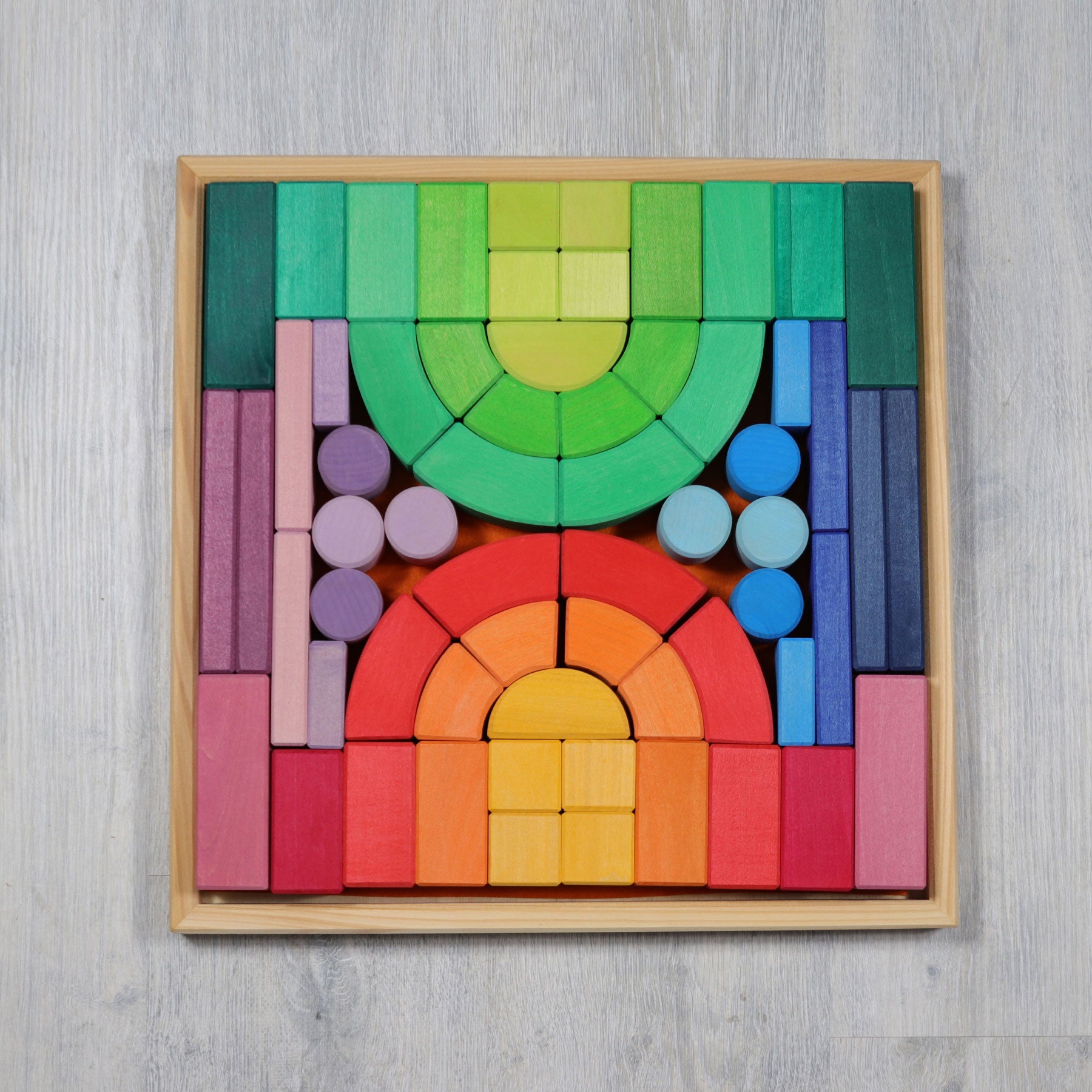 Colorful wooden block set arranged in a geometric pattern on a gray background