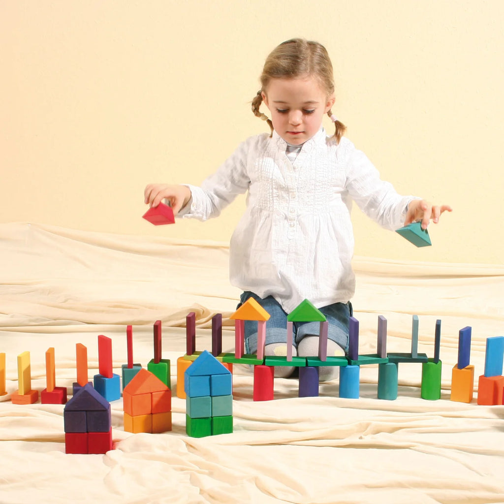 Child playing with colorful wooden blocks on a beige surface