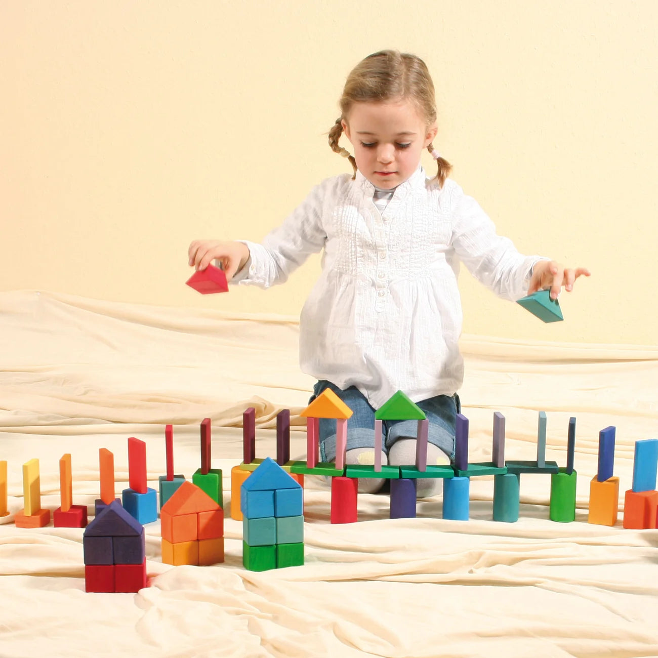 Child playing with colorful wooden blocks on a beige surface