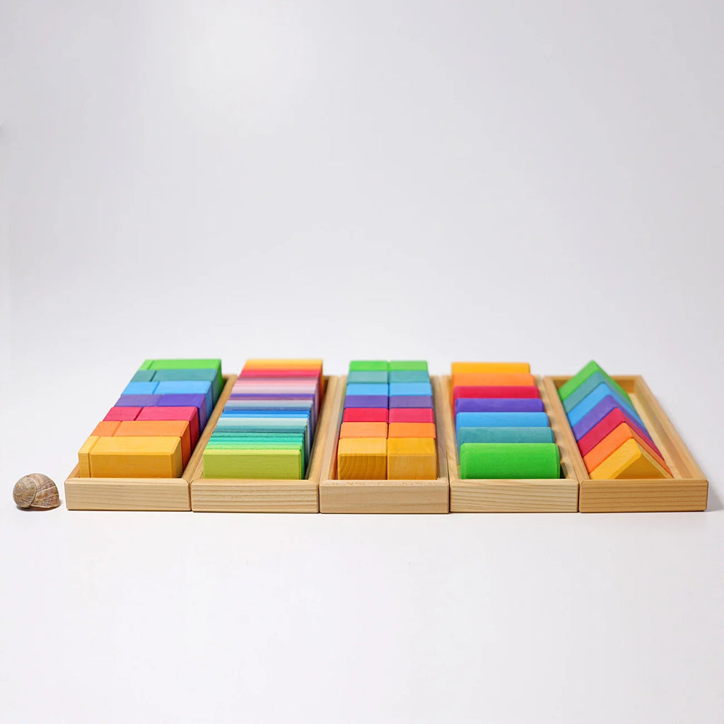 Colorful wooden blocks in a wooden tray on a white background