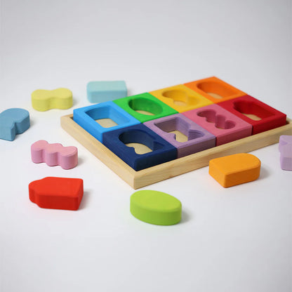 Colorful wooden shape sorting toy with various colored blocks on a white background
