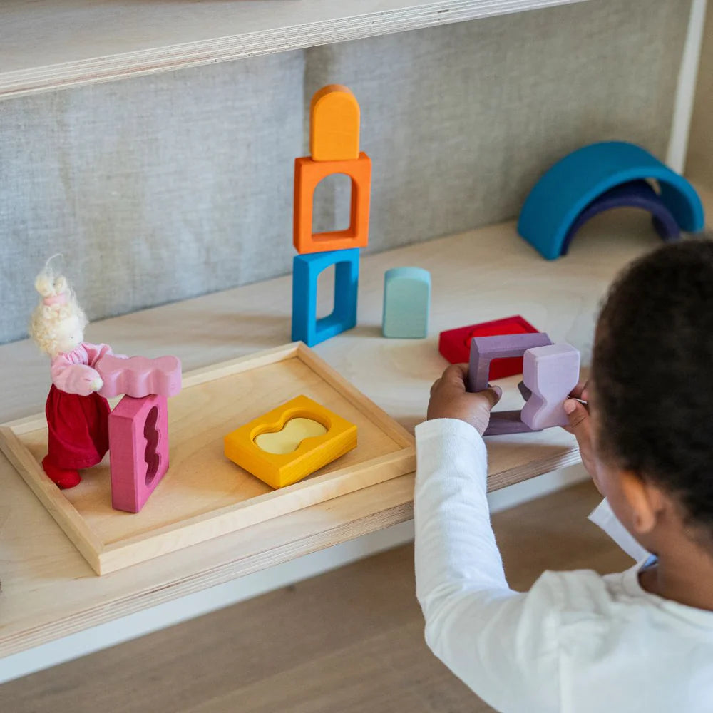 Child playing with colorful wooden toys on a shelf