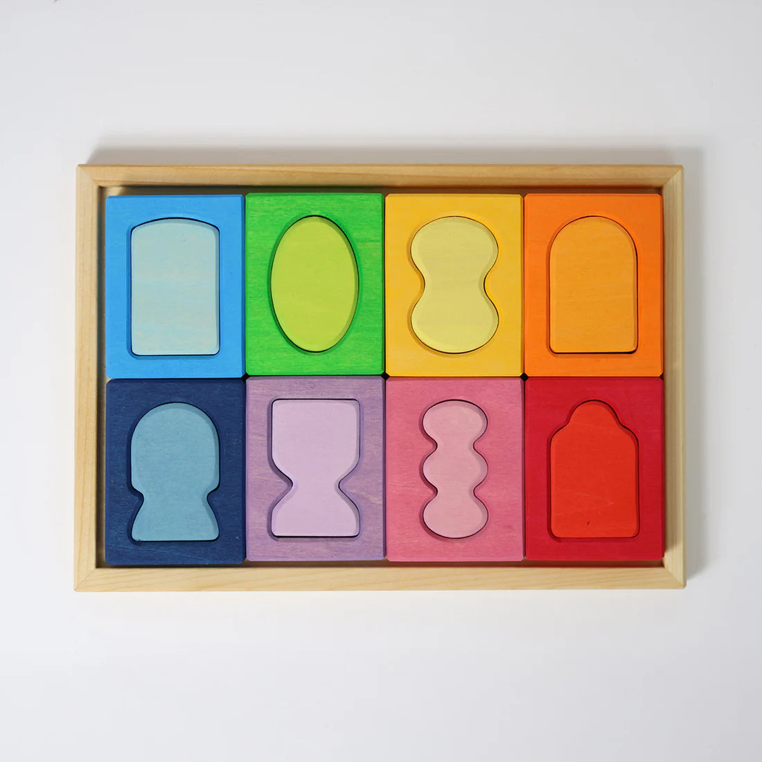 Colorful wooden puzzle with various shapes in a wooden box on a white background