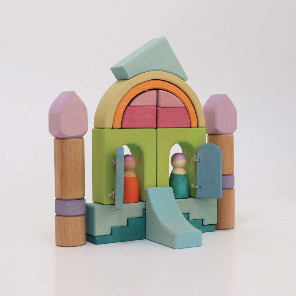 Colorful wooden toy set with arches, slides, and figures on a white background
