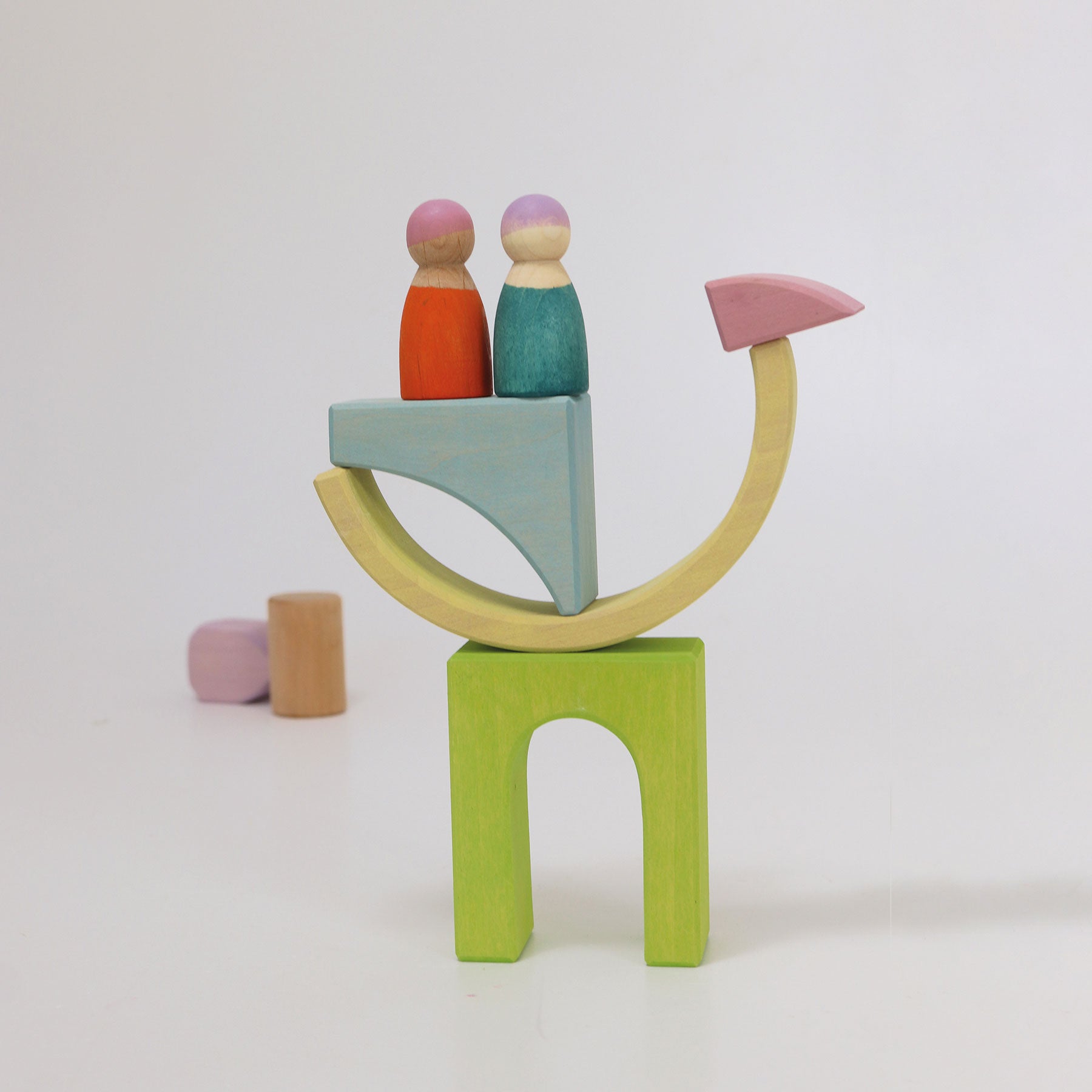 Colorful wooden toy set with two peg people on a white background