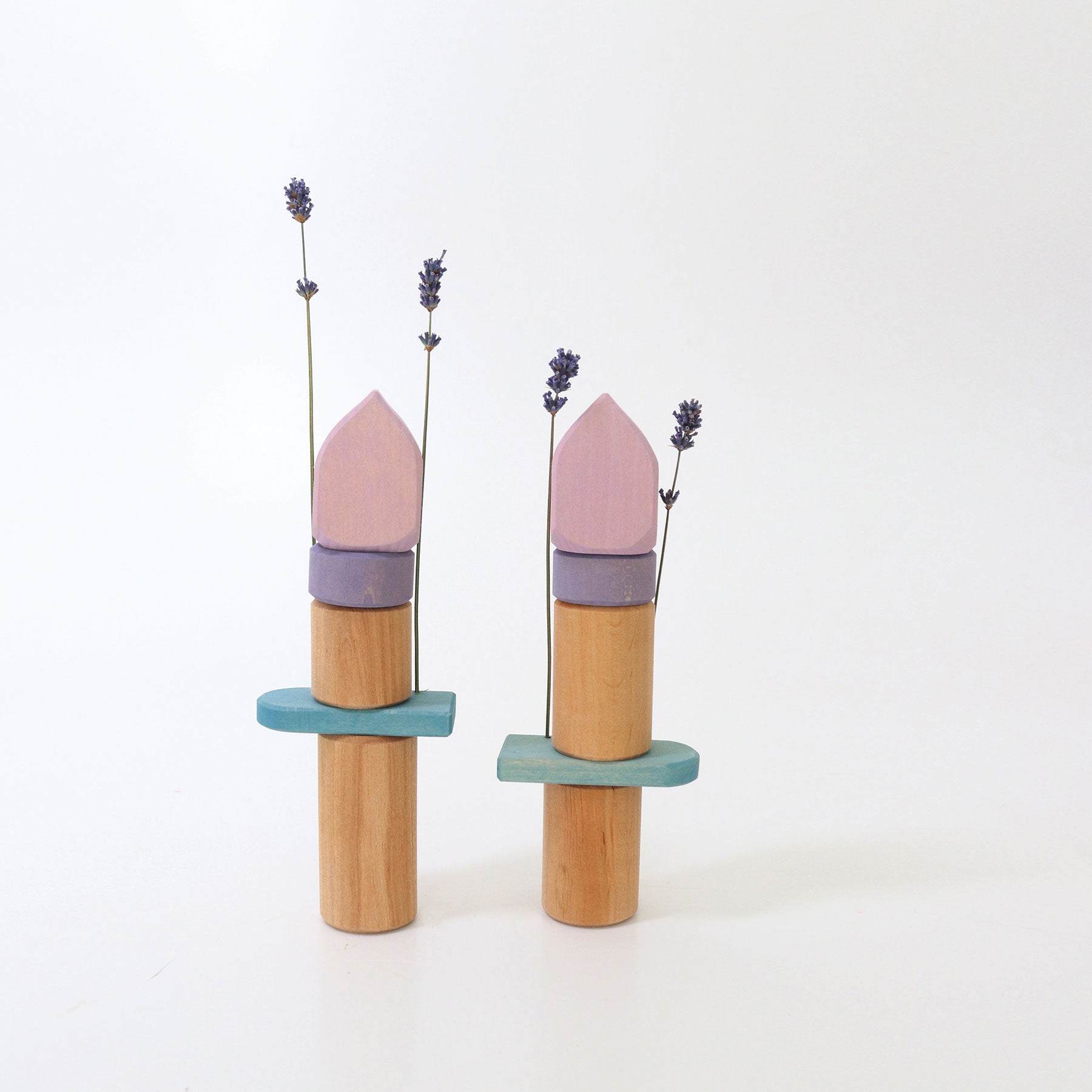 Two wooden towers and dried lavender on a white background