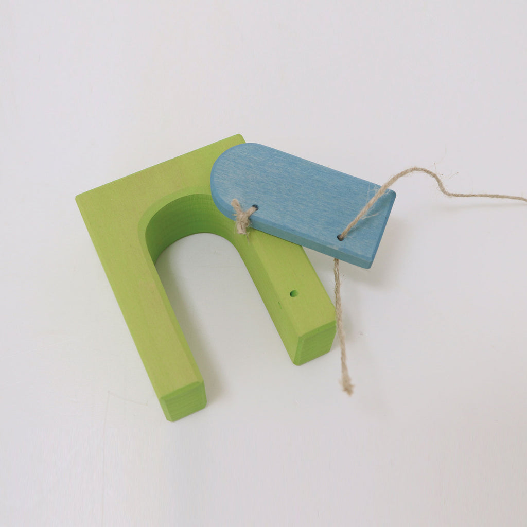 Green and blue wooden toy on a white background