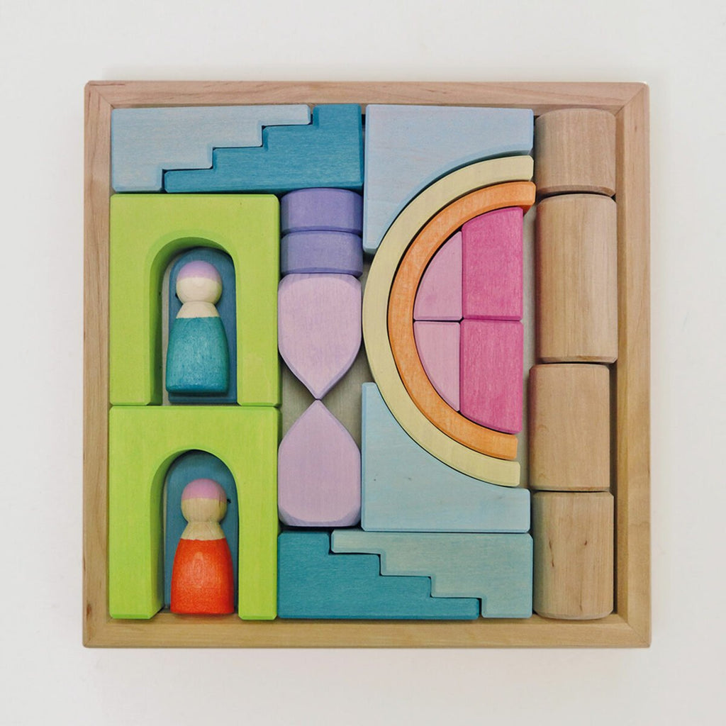 Colorful wooden building blocks with geometric shapes and small figurines on a light background